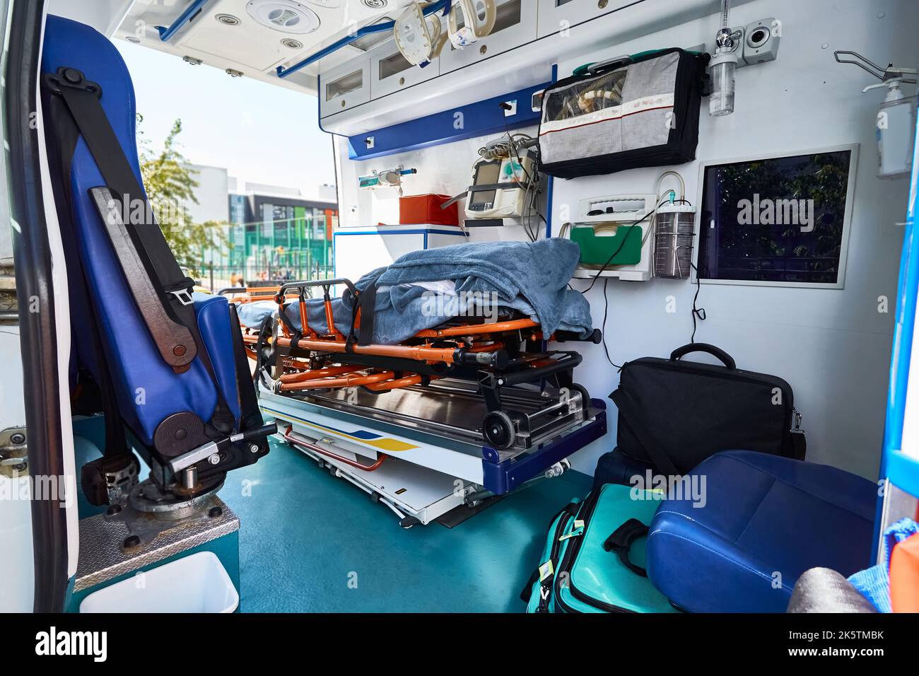 Ambulanzraum mit Liege, Defibrillator und anderen medizinischen Geräten und Hilfsgütern an Bord. EMS Stockfoto