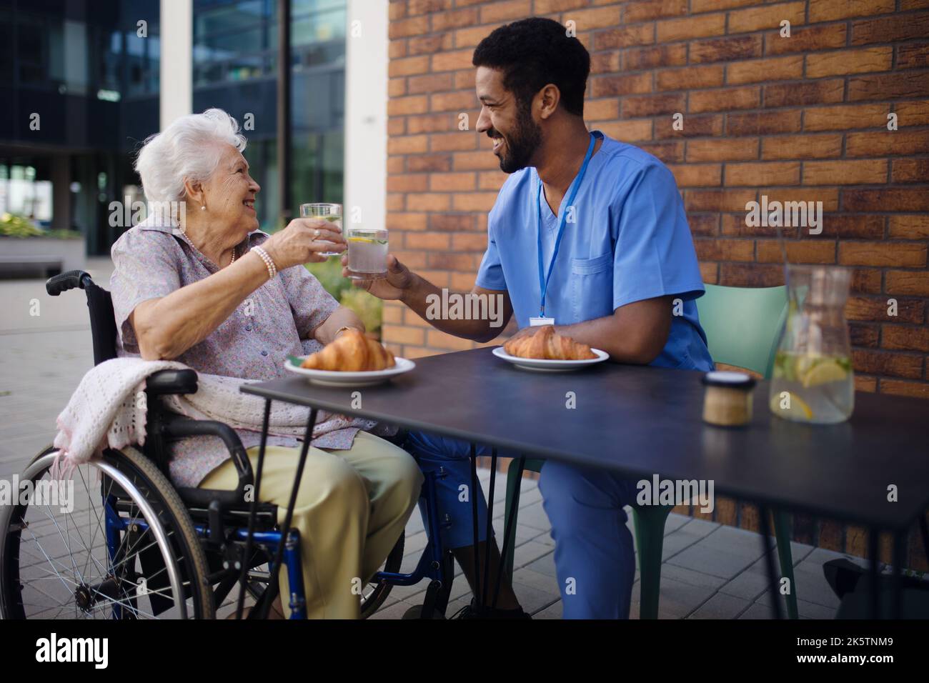 Pfleger beim Frühstück mit seinem Kunden im Café. Stockfoto