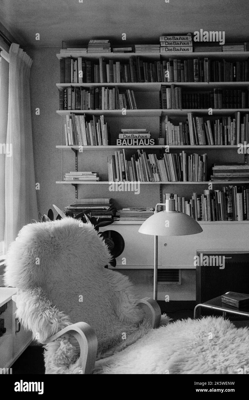 Ein Stuhl mit Schafskelze und Bücherregale im Wohnzimmer des historischen Gropius House in Lincoln, Massachusetts, das vom Bauhaus beeinflusst wurde. Das Bild wa Stockfoto