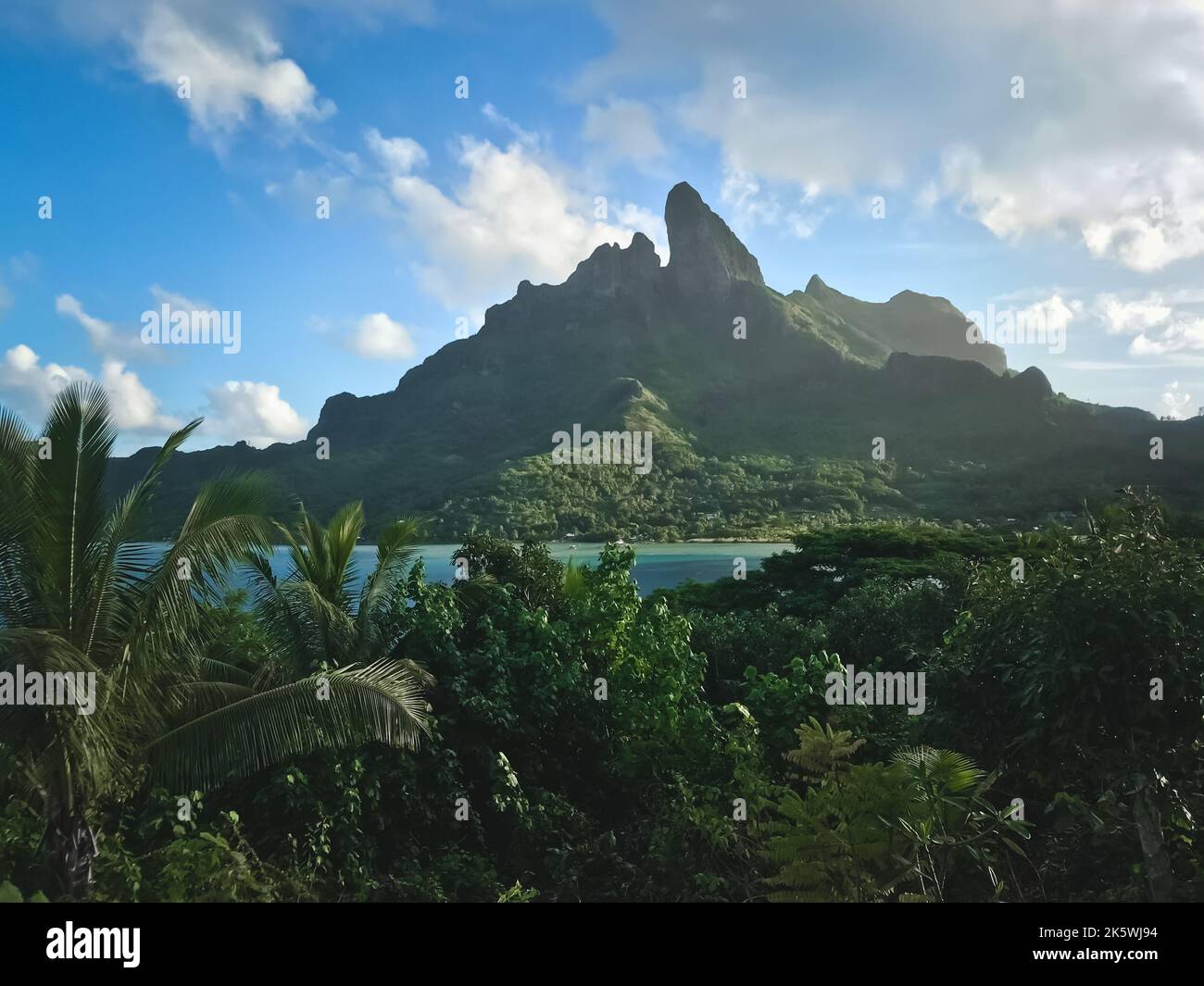 Bora Bora Berglandschaft. Grüner Wald tropische Insel Szene gegen blau bewölkten Himmel. Wunderschöne wilde Natur. Beliebtes Touristenziel. Reisen nach Polynesien, Tourismus, Abenteuer, Konzept Bild. Stockfoto