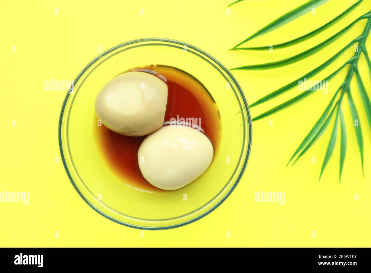 Eier und Sojasauce in einer Schüssel auf gelbem Hintergrund Stockfoto