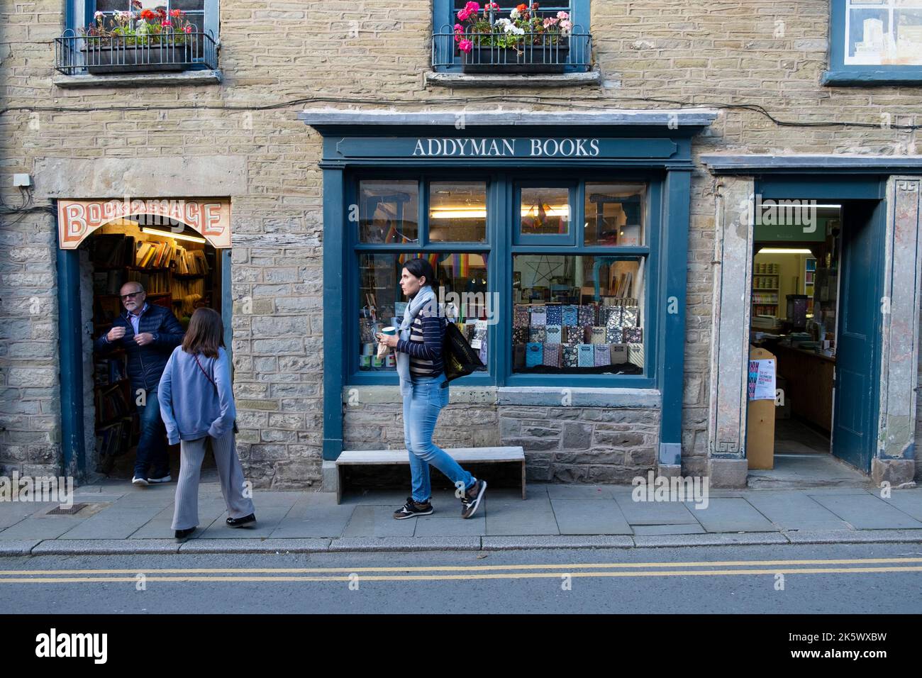 Menschen, die im Herbst am National Bookshop Day vor dem Addyman-Buchladen in der Buchstadt Hay-on-Wye Powys Wales UK KATHY DEWITT auf der Straße spazieren Stockfoto