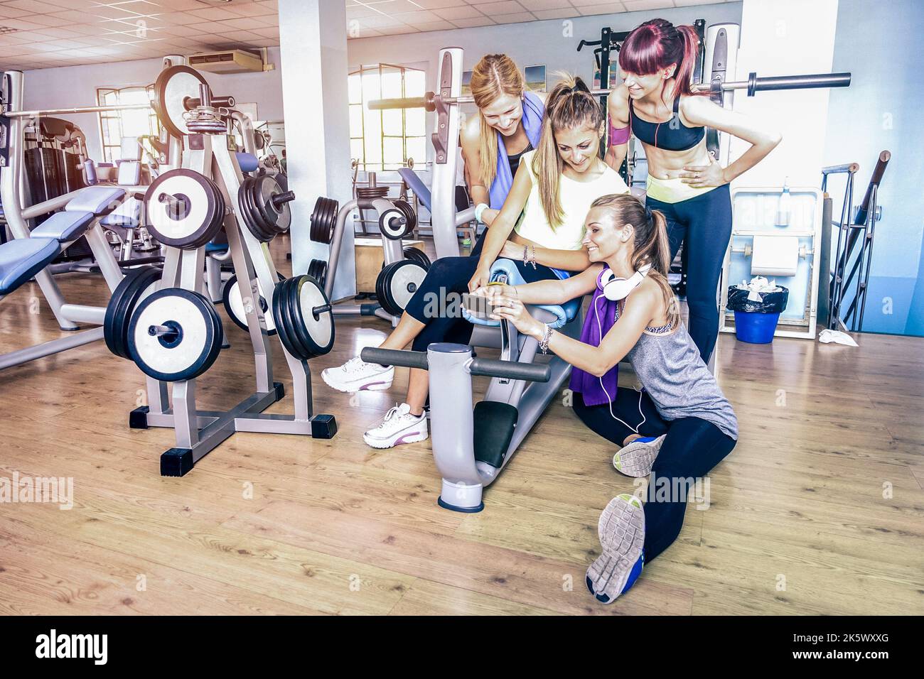 Eine Gruppe sportlicher junger Frauen, die Selfie mit dem Handy im Fitnessclub machen - Glückliche sportliche Menschen im Fitnessstudio - Sozial Stockfoto