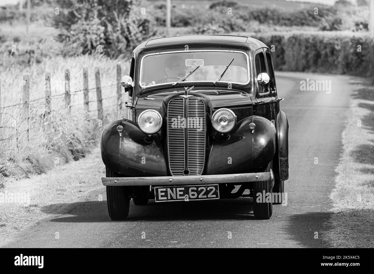 1938 Hillman Minx fährt eine sehr enge Landstraße entlang. Stockfoto