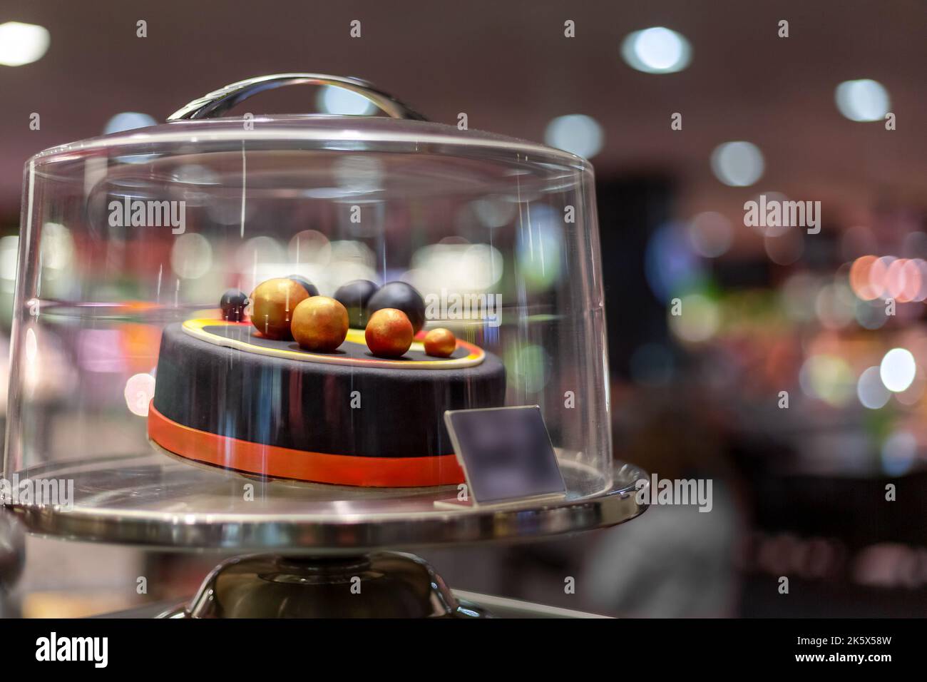 Elite dekorierter Kuchen mit Kugeln in einer Glaskonditorei Vitrine. Stockfoto