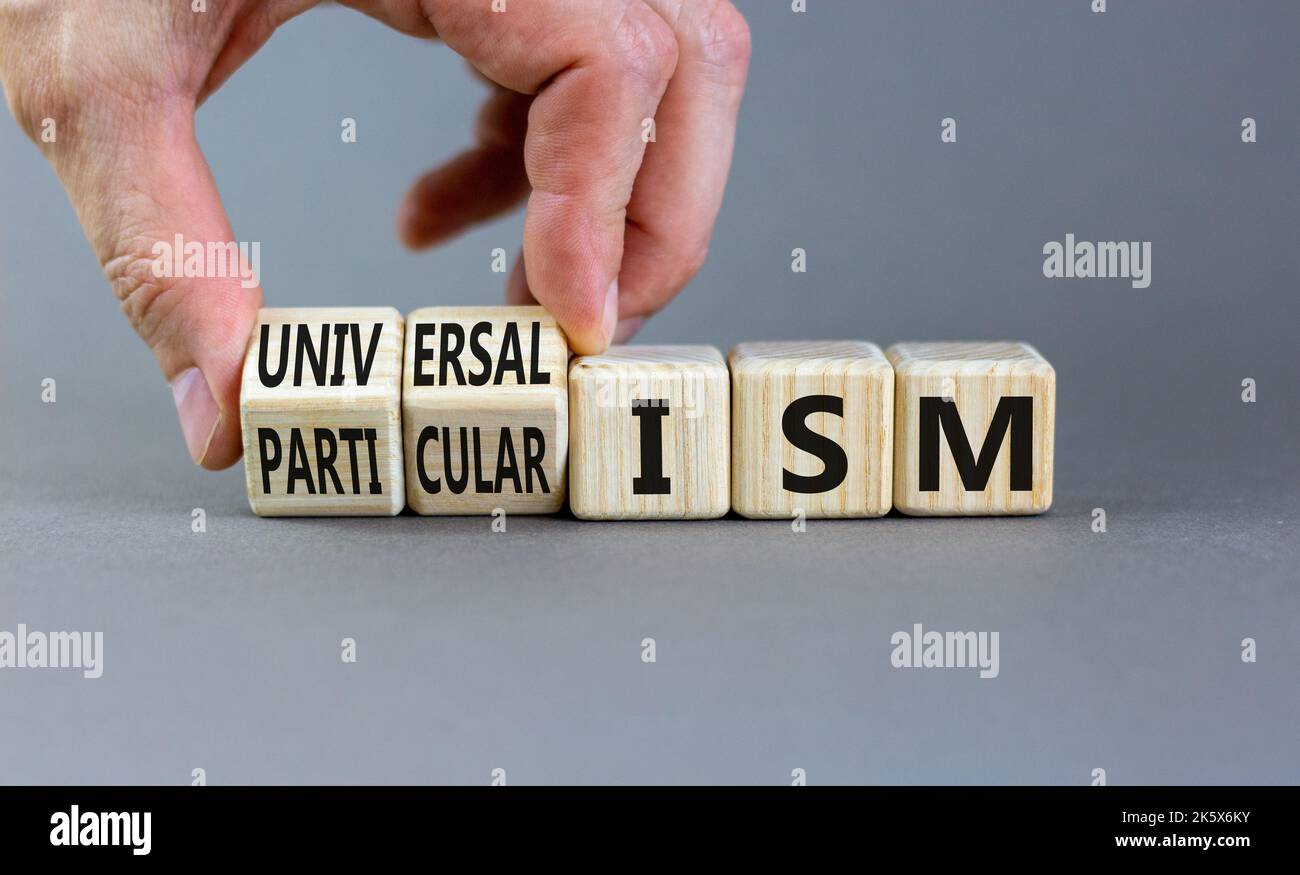 Universalismus oder Partikularismus Symbol. Begriff Wörter Universalismus oder Partikularismus auf Würfel. Geschäftsmann Hand. Schöner grauer Hintergrund. Business Univ Stockfoto