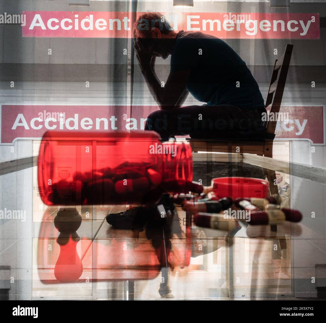 NHS Krankenhaus Unfall- und Notaufnahme mit Bild eines Mannes mit Kopf in den Händen. Überarbeiteter Arzt, Stress, psychische Gesundheit, Ärzte... Konzept. Stockfoto