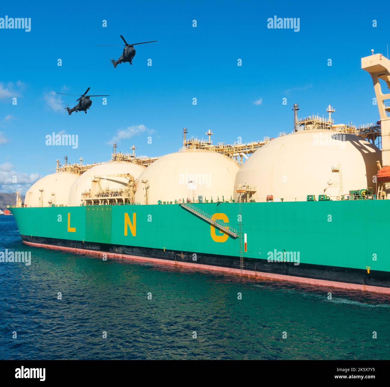 Militärhubschrauber fliegen über, eskortieren Schiff mit Flüssigerdgas, Rotes Meer, Composite-Bild. Gas, Energiepreise, Russland Ukraine Krieg. Stockfoto