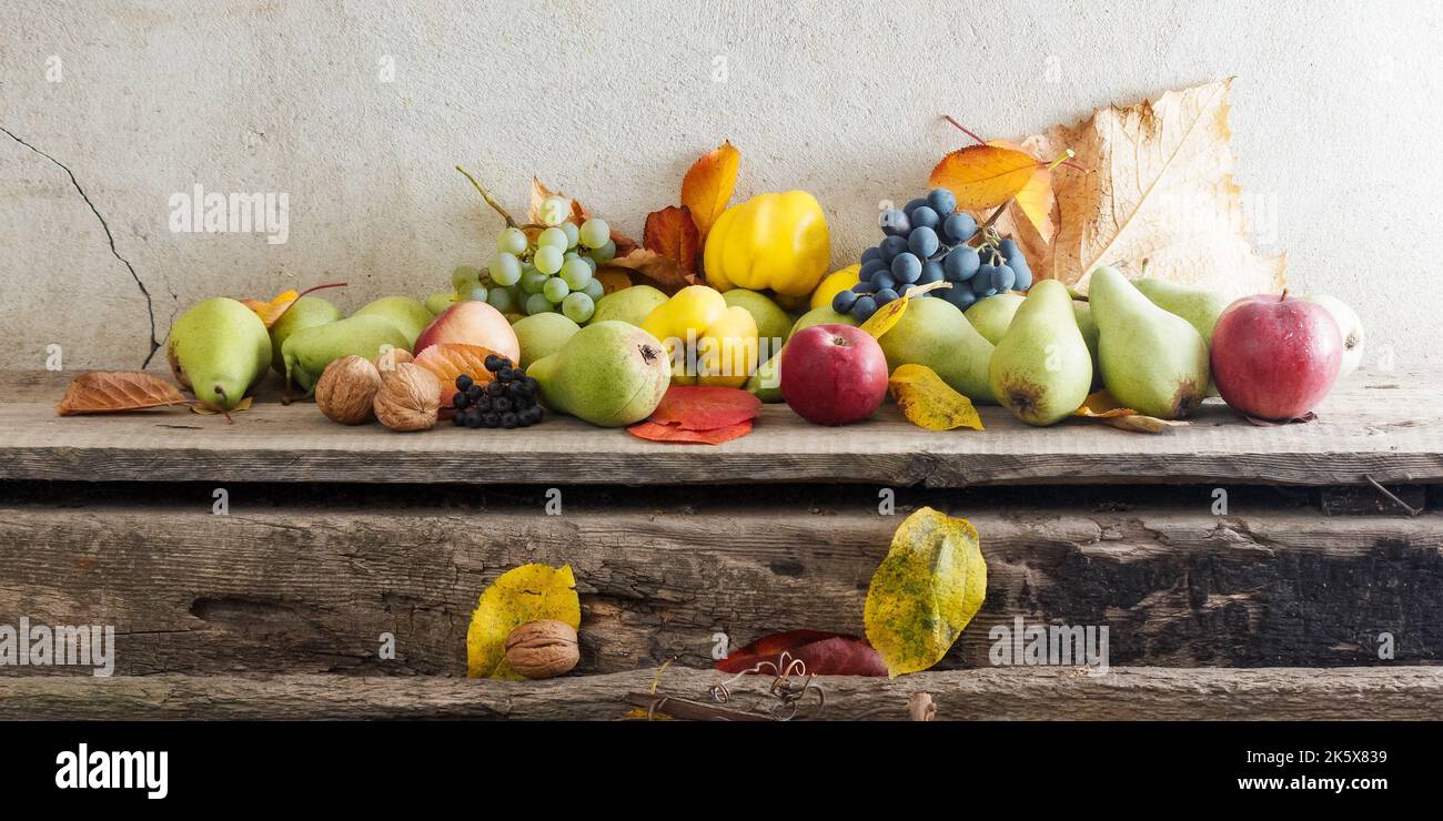 Ländliche Ernte auf dem Holzbrett. Bund von reifen Früchten. Bio gesunde Lebensmittel und rustikale Stillleben Zusammensetzung Stockfoto