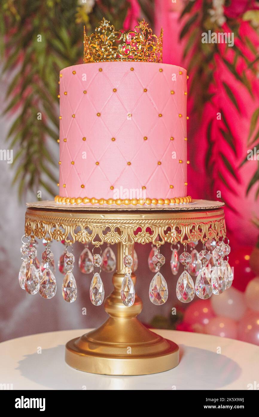 Schöner rosafarbiger Kuchen mit Krone oben. Stockfoto