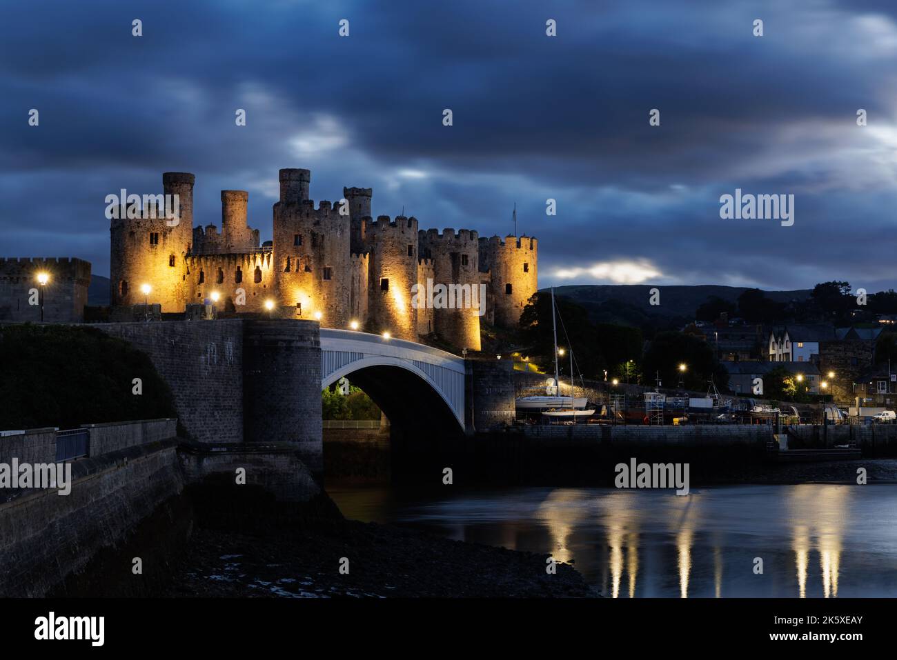 Conwy, Wales, UK, September 28. 2022: Bei Einbruch der Dunkelheit erleuchtet Edward I.'s berühmtes und gut erhaltenes Schloss am Ufer des Flusses Conwy. Stockfoto