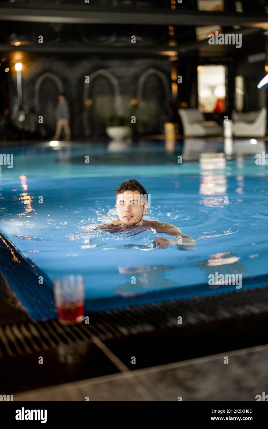 Mann, der im Pool im Spa Resort schwimmt Stockfoto