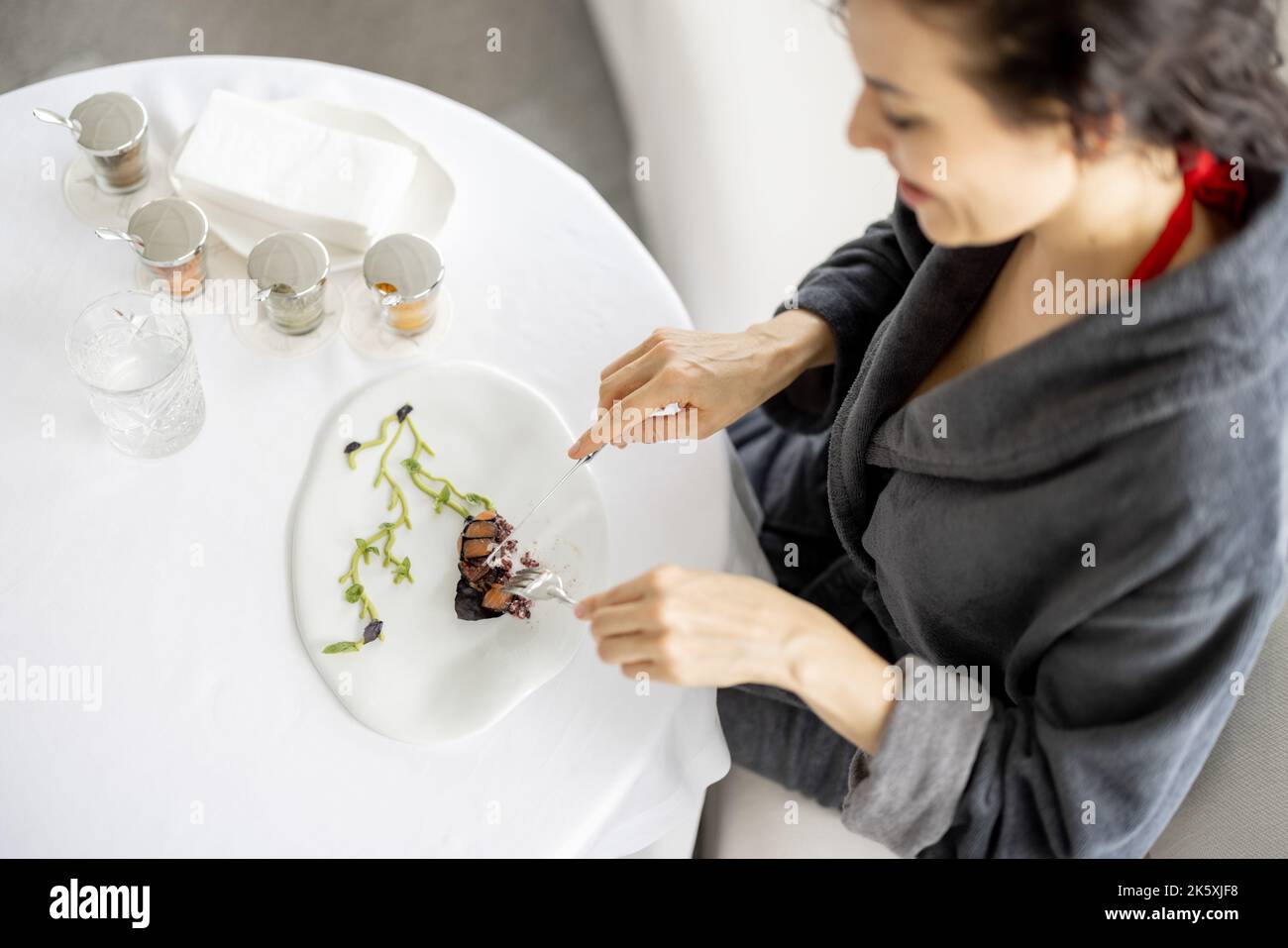 Die Frau hat ein Abendessen im Restaurant mit hochmühter Küche Stockfoto