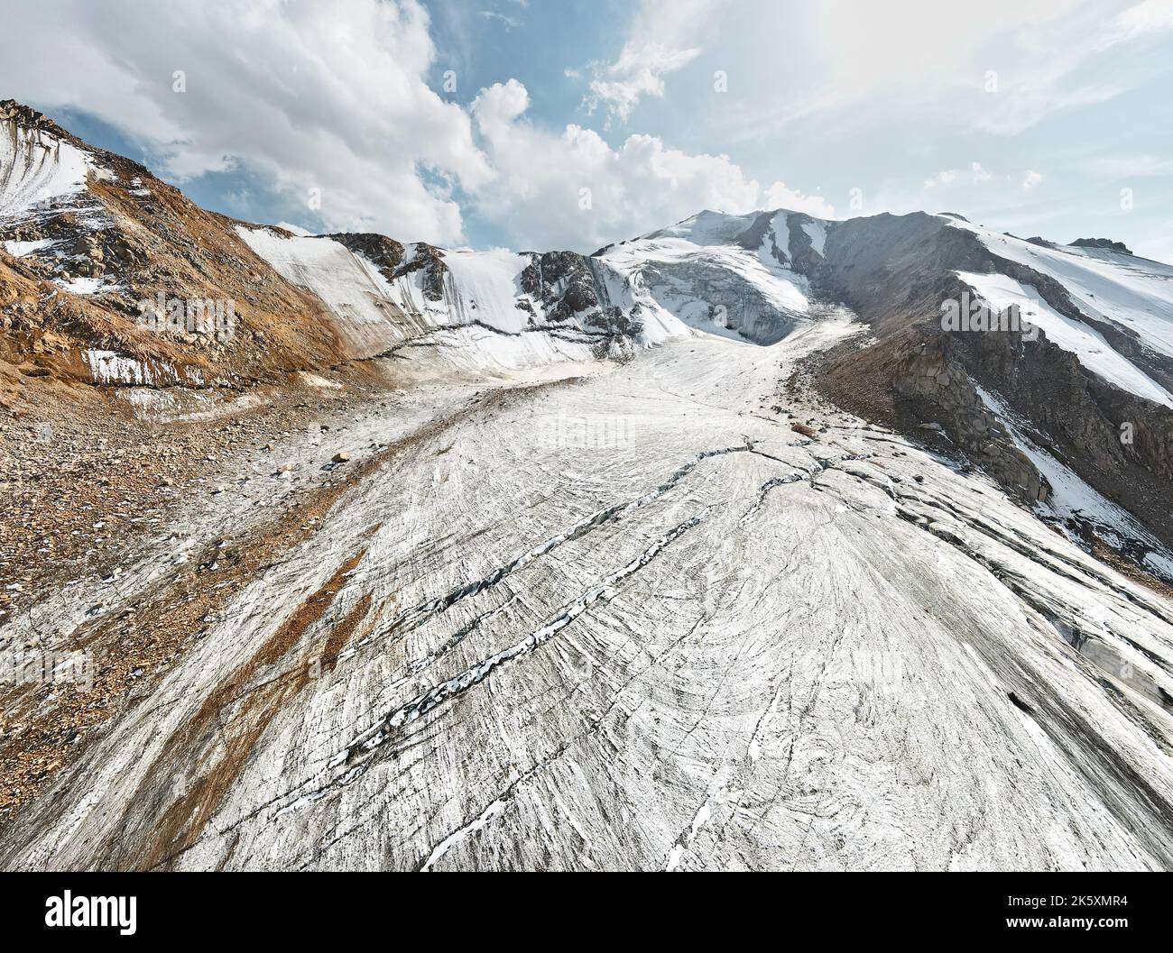 Schöne Landschaft des Eisgletschers mit Riss und Schneekappe von Bergen in der Nähe von Almaty Stadt, Kasachstan. Luftaufnahme mit Drohne von oben nach unten im Freien Stockfoto