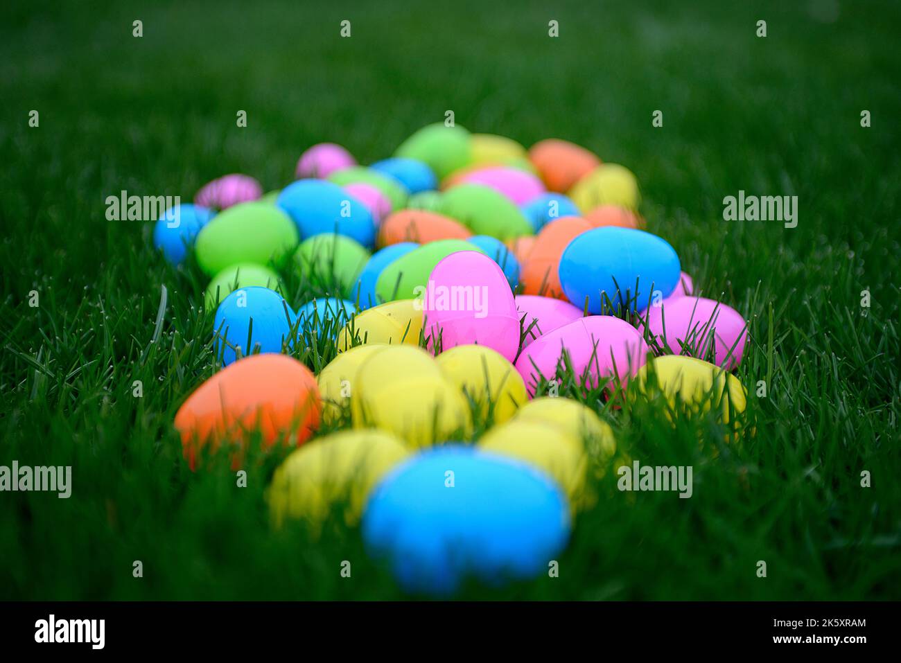 Bunte Kunststoff-Ostereier auf grünem Gras, selektiver Fokus Stockfoto