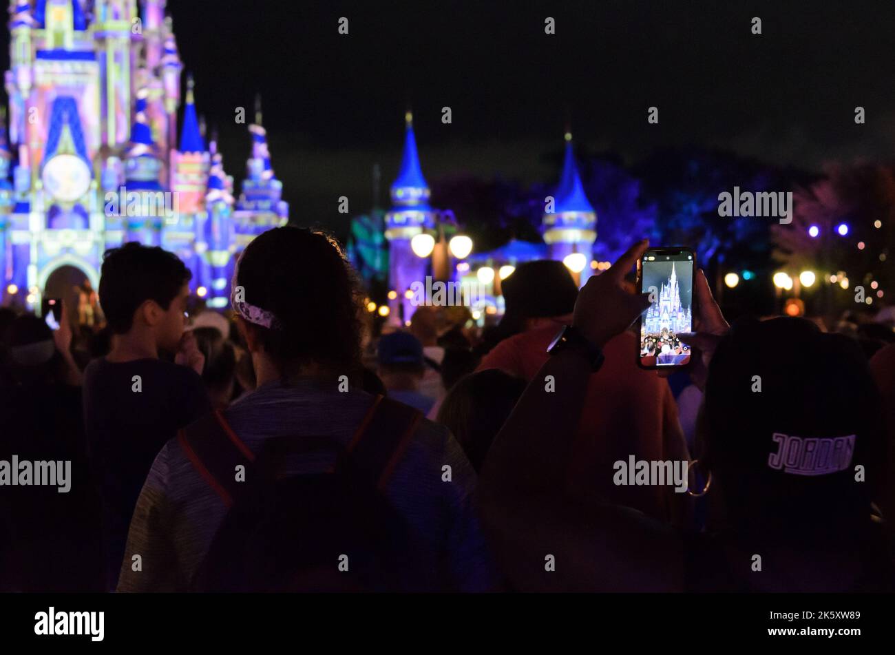 Eine Person, die in Disney World in Orlando, Florida, ein Foto des Disney Castle auf ihrem Handy auffängt. Stockfoto
