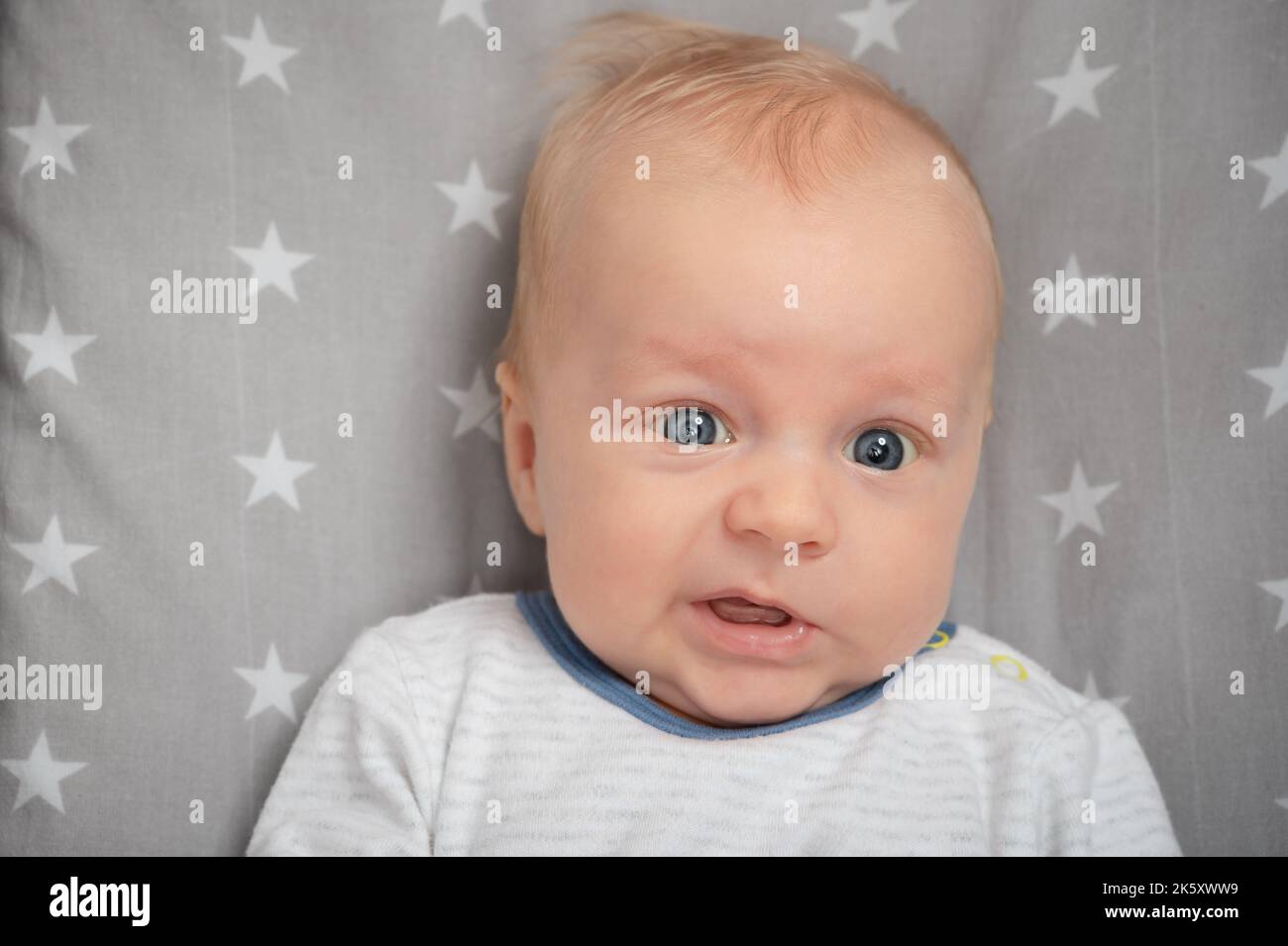 Porträt eines überraschten Neugeborenen, Nahaufnahme. Schnitt Kind mit blauen Augen, Blick auf die Kamera. Gesichtsausdruck. Stockfoto