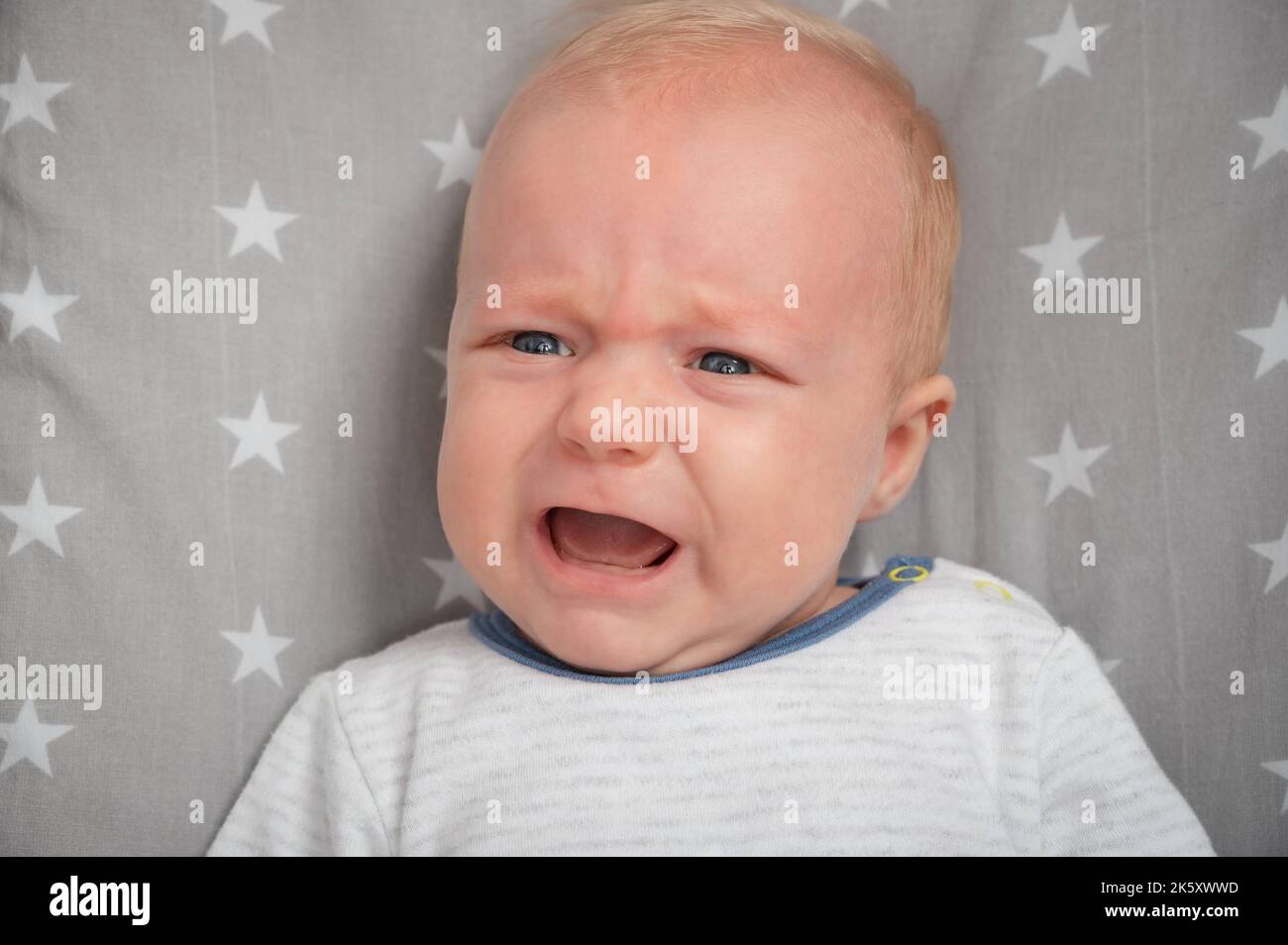 Porträt eines weinenden Neugeborenen, Nahaufnahme. Schneiden Sie das Kind mit blauen Augen. Gesichtsausdruck. Stockfoto