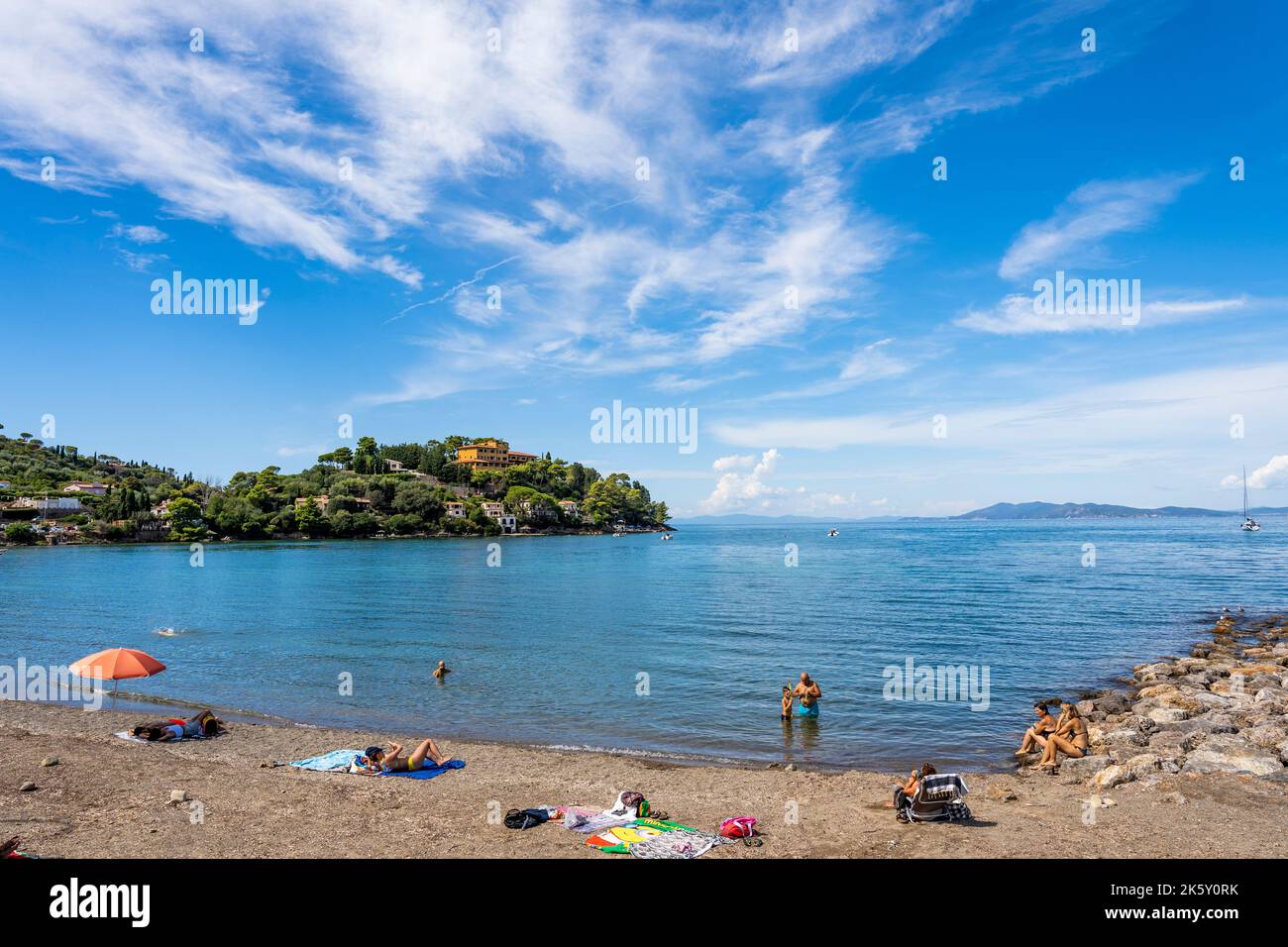 Pozzarello Strand mit Sonnenanbetern und Touristen, in porto Santo Stefano entlang der Küste des Monte Argentario, Provinz Grosseto, Toskana, Italien Stockfoto