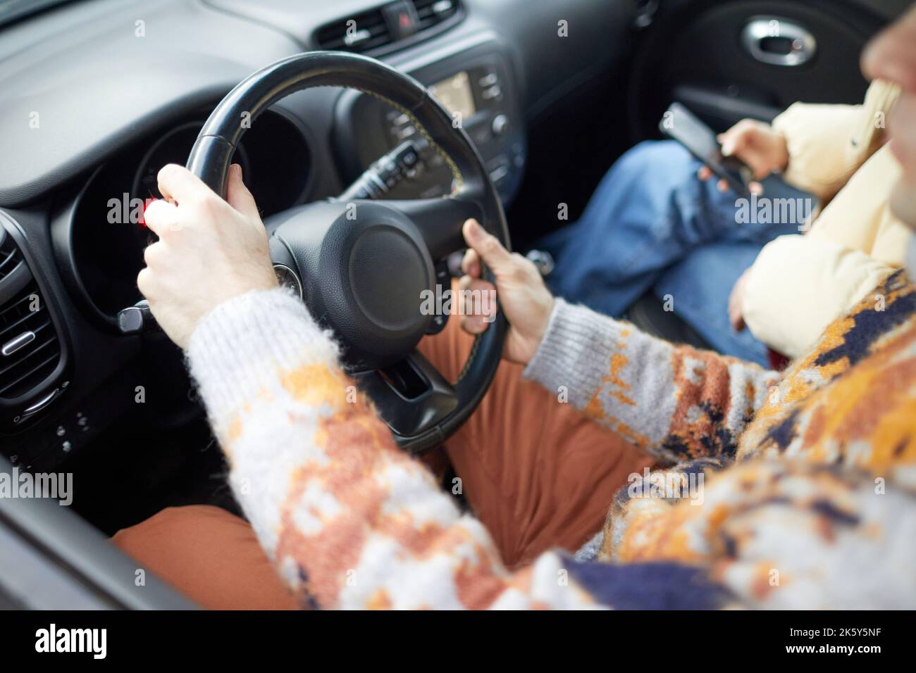 Nahaufnahme einer jungen Frau, die im Winter Auto fährt, Fokus auf weibliche Hände am Rad, Kopierraum Stockfoto