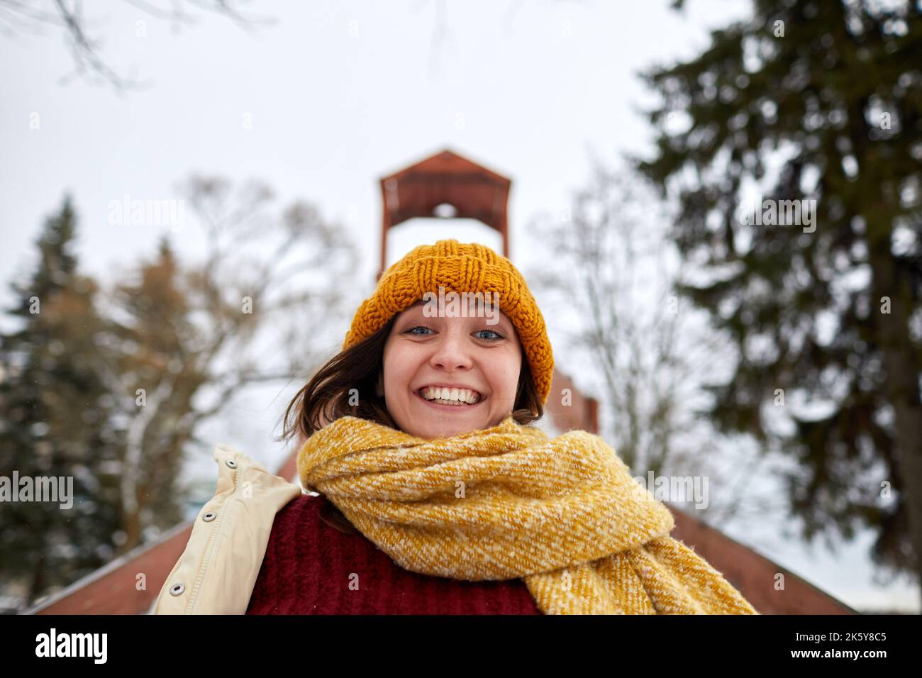 Porträt einer aufgeregten jungen Frau, die im Winter bergab Schlitten fährt Stockfoto