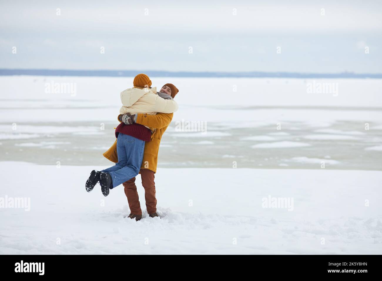 Porträt eines sorglosen jungen Paares, das sich in einer minimalistischen Winterlandschaft umarmt und Platz zum Kopieren bietet Stockfoto Porträt eines sorglosen jungen Paares, das sich in einer minimalistischen Winterlandschaft umarmt und Platz zum Kopieren bietet Stockfoto