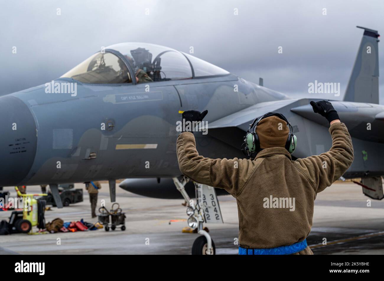 Ein US Air Force Airman unterstützt einen F-15C/D Eagle-Piloten, während er mit dem Taxi zur Position während DER ROTEN FLAGGE Alaska 23-1 auf der Eielson Air Force Base, Alaska, am 7. Oktober 2022, taxiert. RF-A ist eine zweiwöchige fortgeschrittene Luftkampfübung, die darauf abzielt, Militärpiloten und anderen Flugbesatzungsmitgliedern aus den Vereinigten Staaten und verbündeten Ländern realistische Luftkampftrainings zu bieten. (USA Luftwaffe Foto von Senior Airman David Phaff) Stockfoto