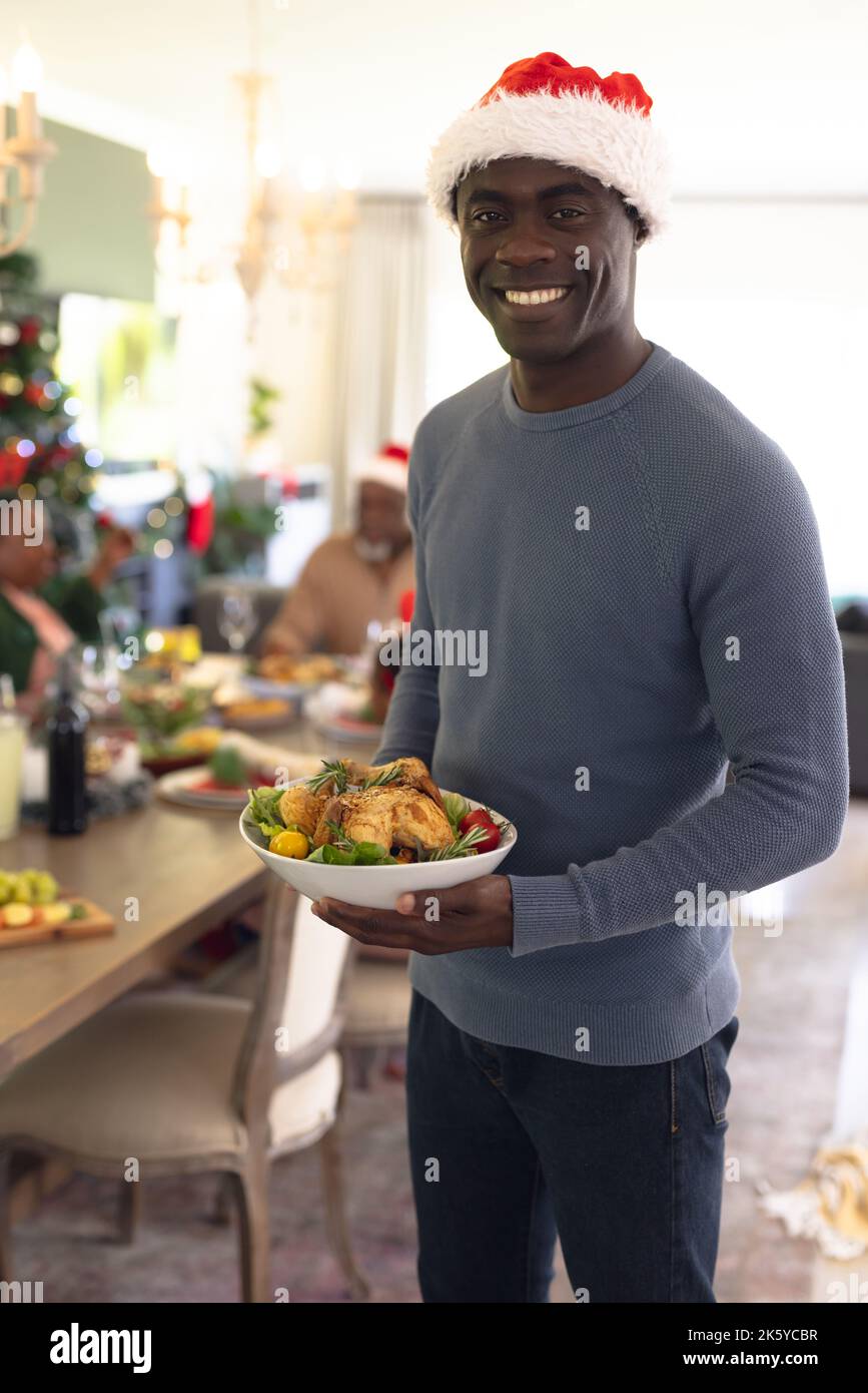 Glückliche afroamerikanische Männer mit Braten, die ein weihnachtsessen essen essen Stockfoto