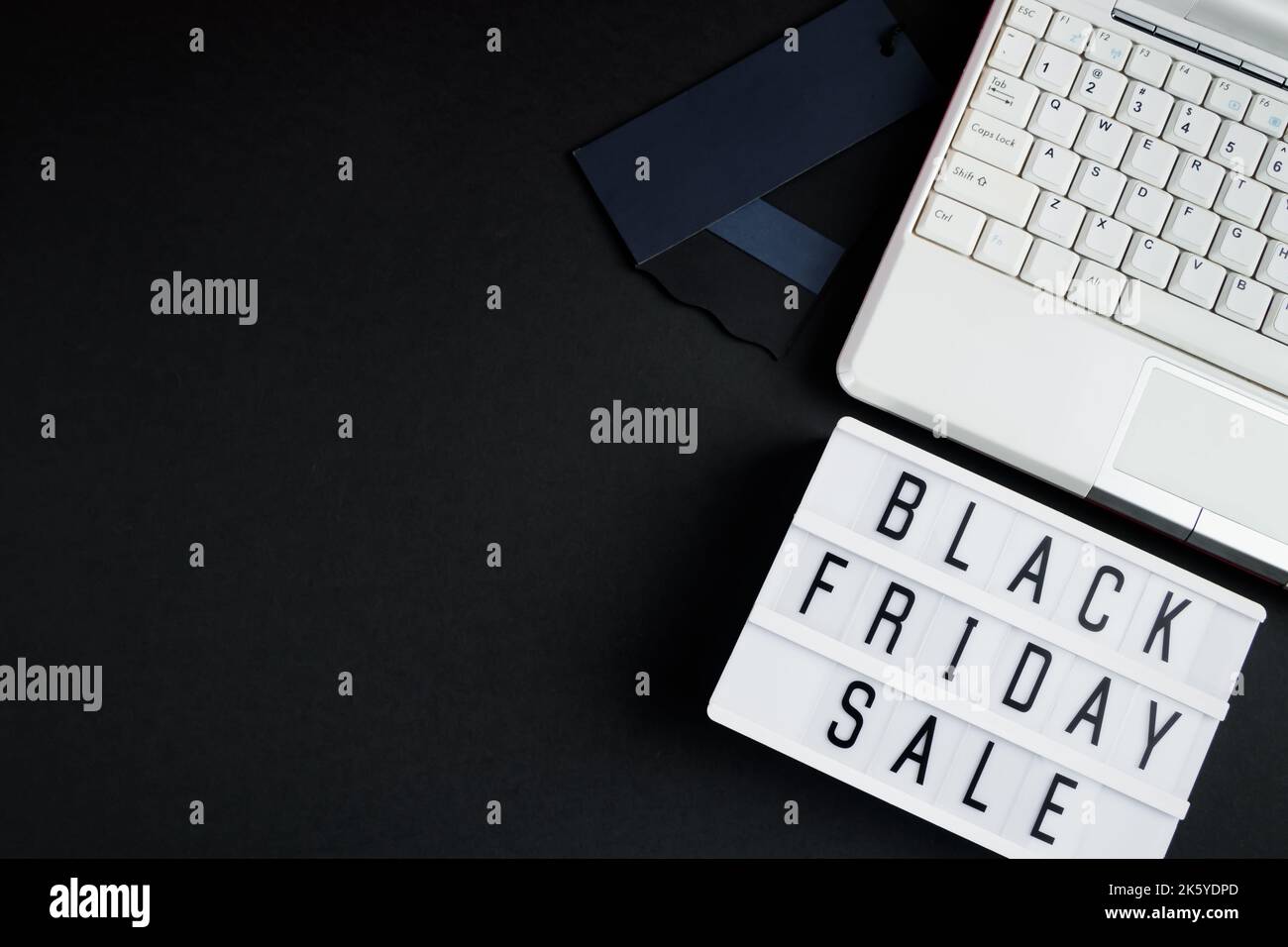 Black Friday Verkaufskonzept. Laptop und Leuchtkasten auf dunklem Hintergrund. Für Text platzieren. Stockfoto