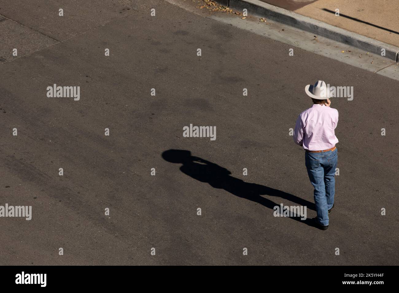 Chandler, Arizona, USA - 4. Januar 2022: Eine Person in einem Cowboyhut überquert eine Straße in der Innenstadt von Chandler. Stockfoto