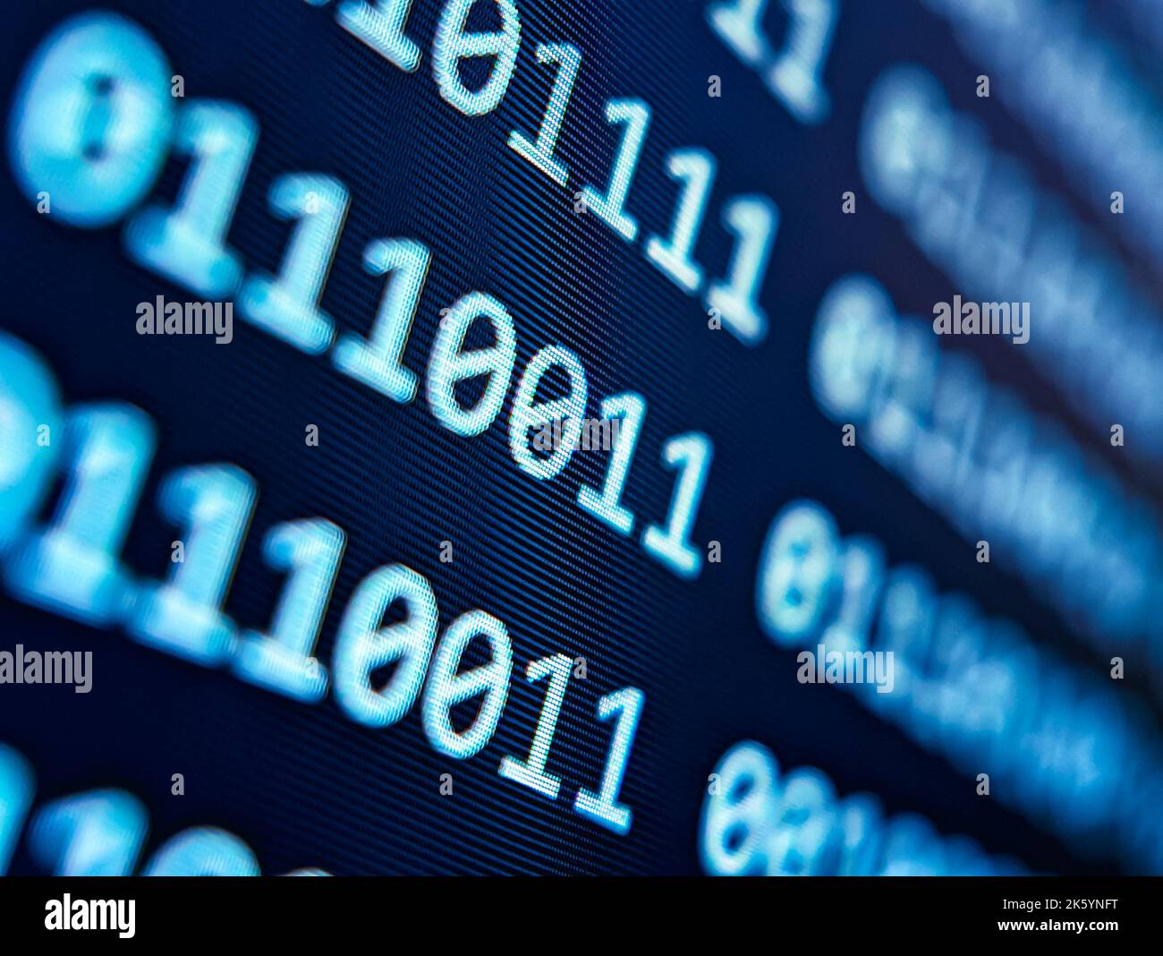 Binärer Computercode mit einem Raster von 1s und 0s, der auf einem blauen Bildschirm mit einem Fokus-Unschärfeeffekt angezeigt wird Stockfoto