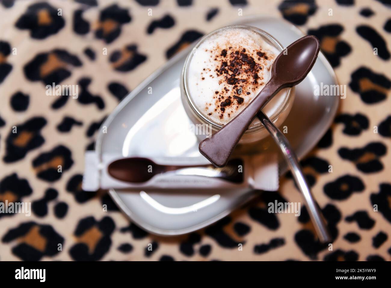 Kaffee mit Milchschaum mit einem Schokoladenlöffel Stockfoto