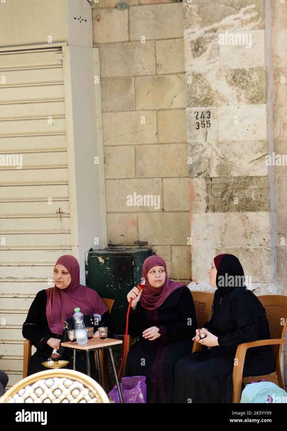 Palästinensische Frauen, die in der Altstadt von Jerusalem Arjīlah ( Hookah ) rauchen. Stockfoto