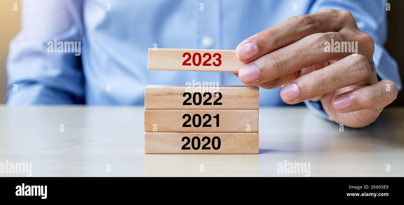 2023 Block über 2022 und 2021 Holzgebäude auf Tischhintergrund. Geschäftsplanung, Risikomanagement, Lösung, Strategie, Lösung, Ziel, Neujahr Stockfoto