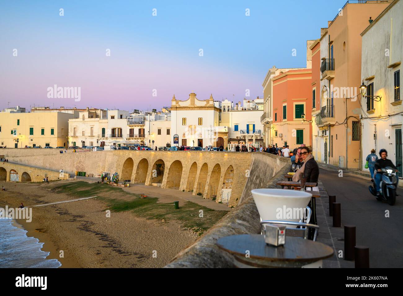 Blick über die Bucht und den Strand (Spiaggia della Purità) und die Uferfassaden der alten Stadthäuser bei Abendsonne in Gallipoli, Apulien, Italien. Stockfoto