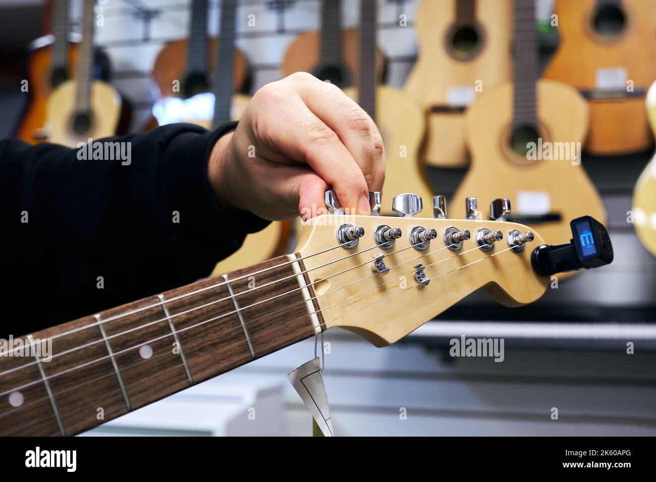 E-Gitarren-Tuning in einem Musikgeschäft Stockfoto