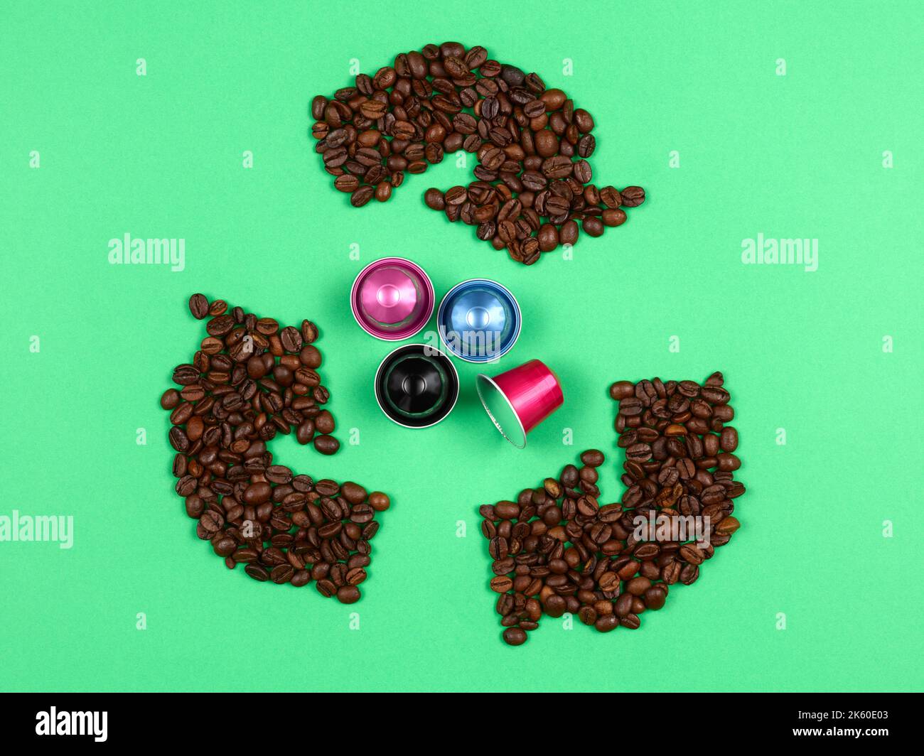 Recycling-Logo mit Kaffeebohnen, die Kaffeekapseln umgeben Stockfoto