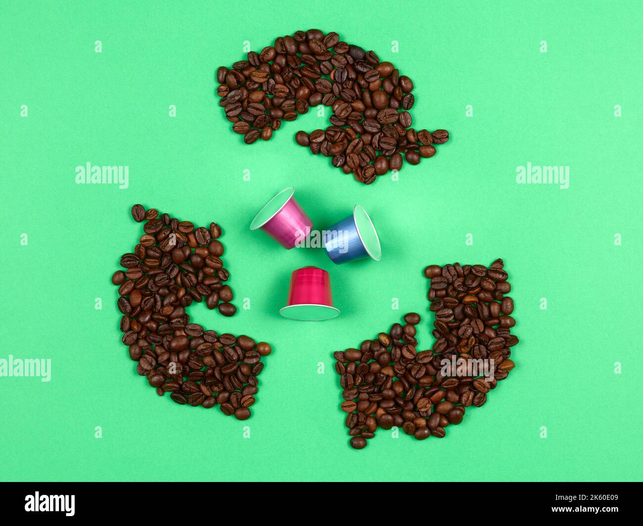 Recycling-Logo mit Kaffeebohnen, die Kaffeekapseln umgeben Stockfoto