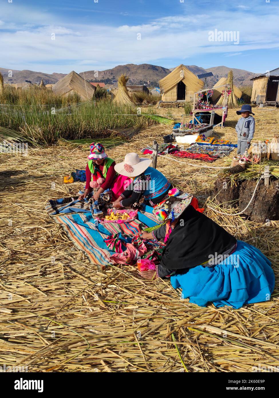 Frauen der Uru- oder Uros-Völker, Ureinwohner Perus und Boliviens, während sie mit Stoffstücken auf ihrer schwimmenden Insel im Titicacasee arbeiteten. Stockfoto