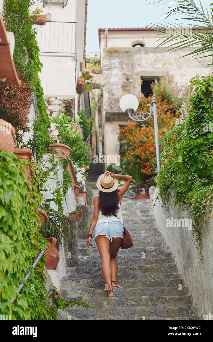 Italien hat so viel zu bieten, auch in seinen Gebäuden. Ganzkörperaufnahme einer unverkennbaren Frau, die allein steht und die Architektur in Italien genießt. Stockfoto