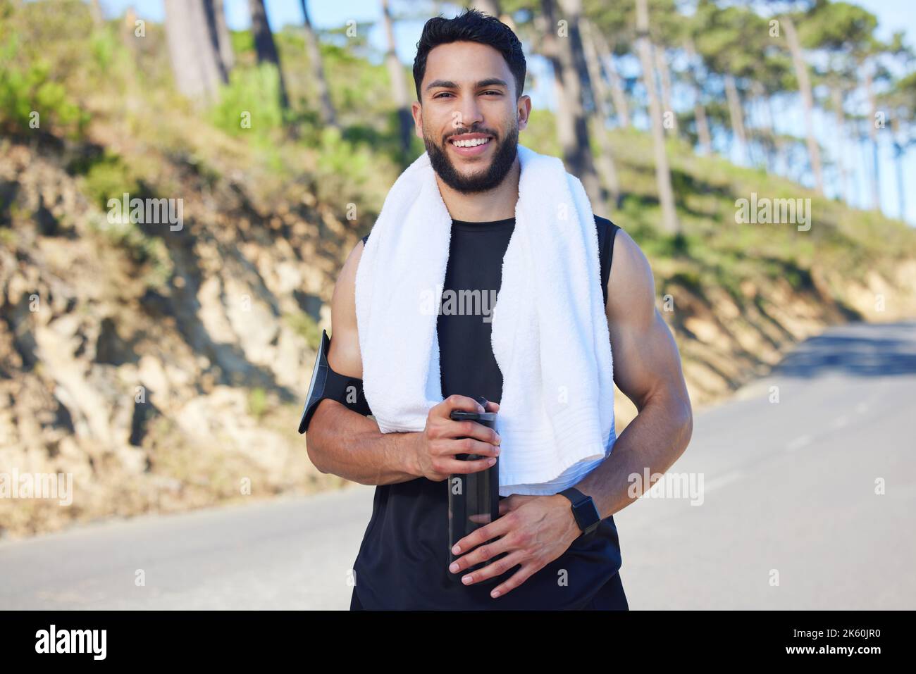 Portrait, Fitness und Mann mit Wasser auf der Straße von Los Angeles nach dem Cardio-Training in der Natur. Glücklich, asmile und entspannen Athlet Läufer mit Stockfoto