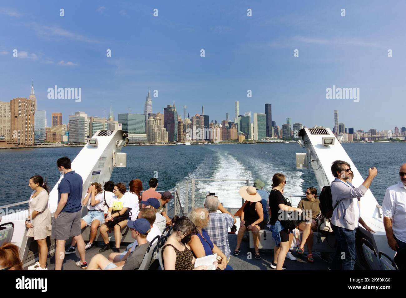 Touristen und Pendler mischen sich auf einer Fähre auf dem East River in New York Stockfoto