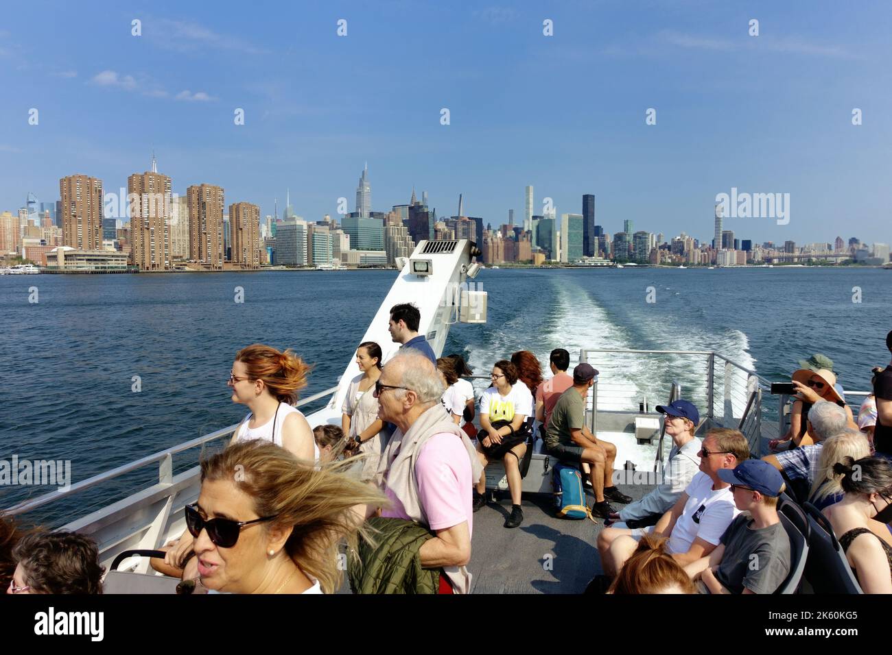 Touristen und Pendler mischen sich auf einer Fähre auf dem East River in New York Stockfoto