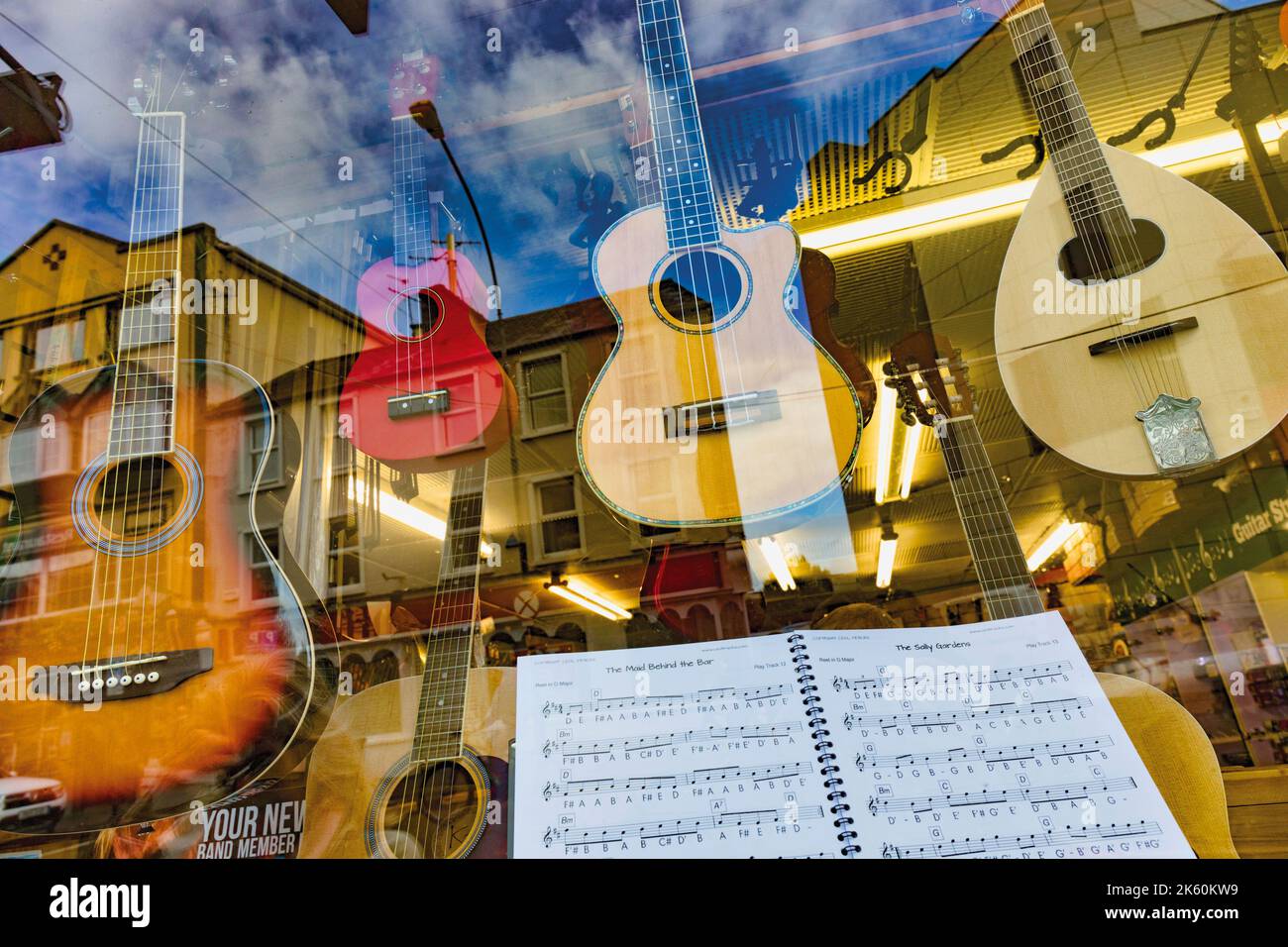 Musikinstrumente und Notenbuch im Window of Variety Sounds Irish Music Store , Killarney, County Kerry, Irland. Gitarren und Mandoline. Stockfoto