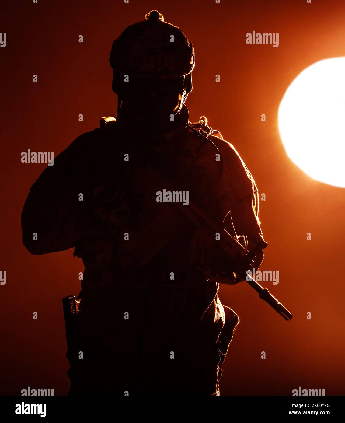 Armeesoldat in Schutzkampfuniform mit Special Operations Forces Combat Assault Rifle, das bei Sonnenuntergang in der Abendsonne eingesetzt wird Stockfoto