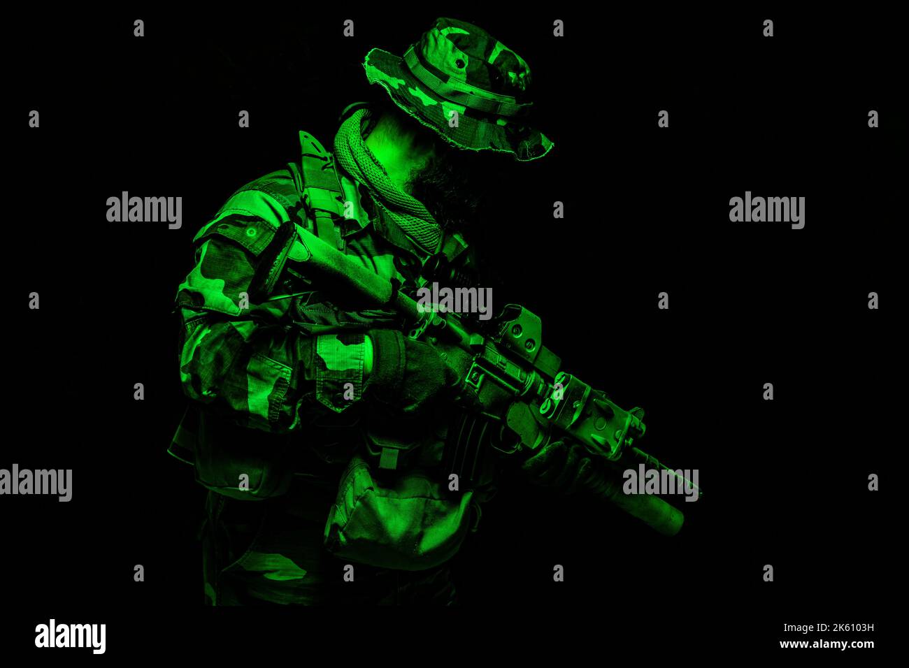 Kommandoschütze, Armee-Spezialeinsatzkommandos in Kampfuniform, Boonie-Hut, Munitionsaufladung im Lastträger, getarnt mit Lackgesicht, bewaffnetem Sturmgewehr, halblanges farbiges Porträt auf schwarzem Hintergrund Stockfoto