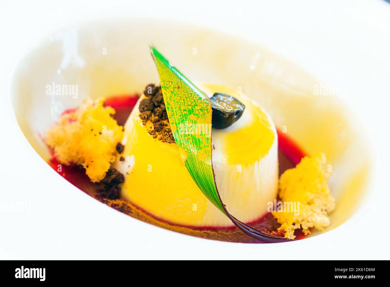 Panna Cotta Dessert mit rotem Sirup und Schokoladentrüffel (Selektiver Fokus) Stockfoto