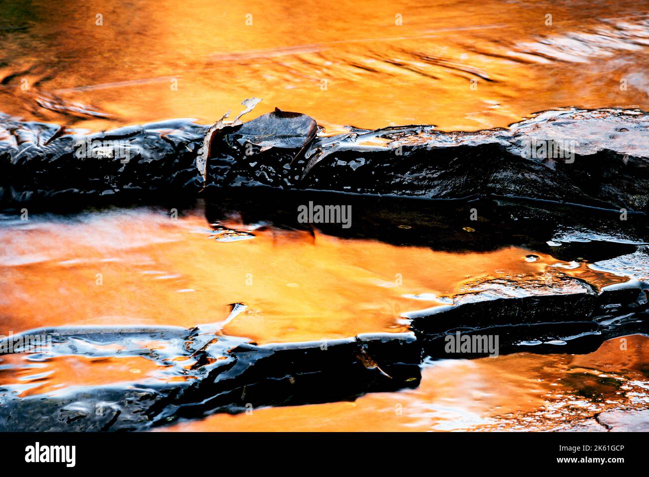Goldene Spiegelungen einer sonnenbeschienenen Felswand in Karijinis Dales Gorge. Stockfoto
