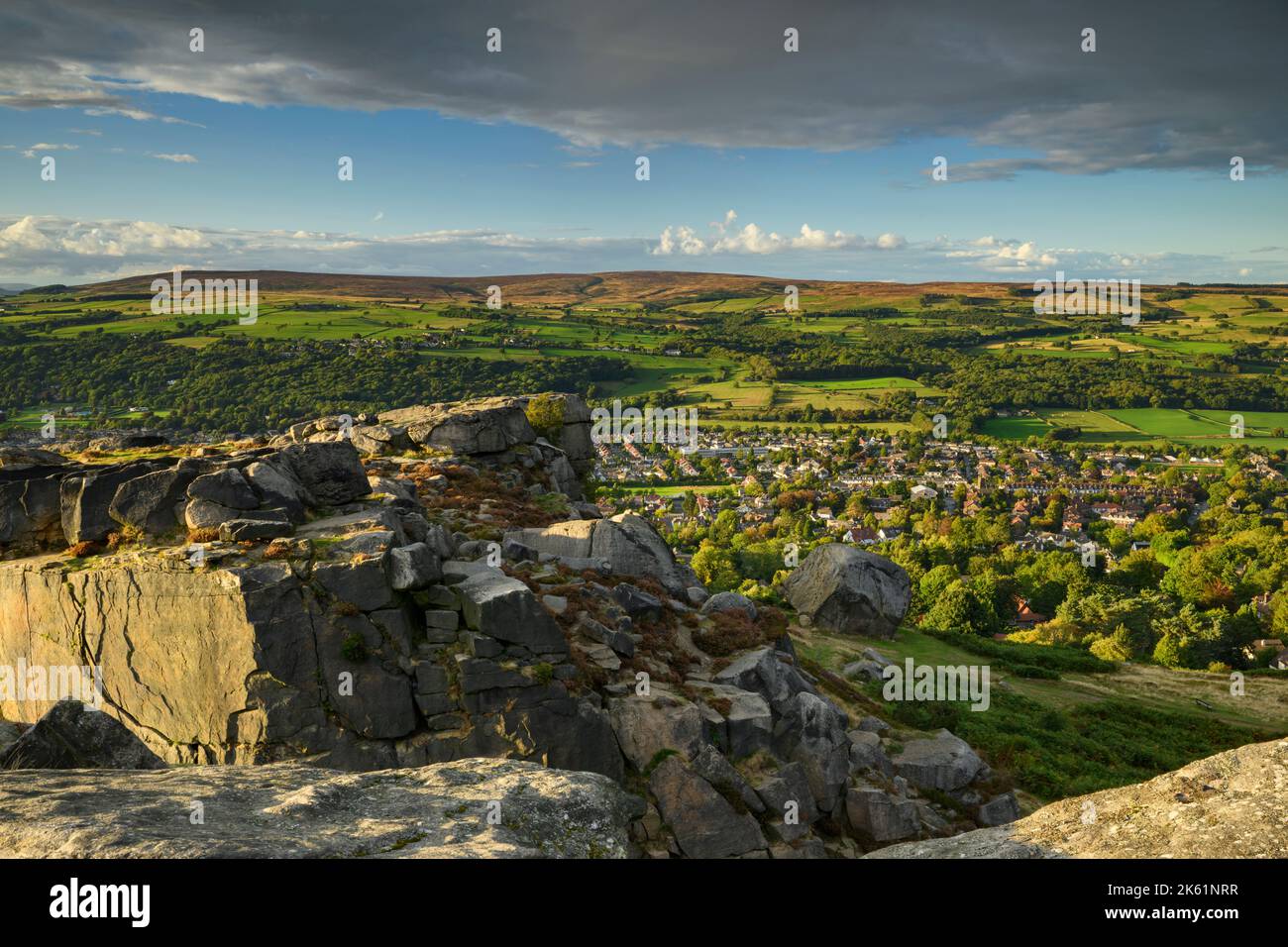 The Cow & Calf Rocks (landschaftlich reizvolle Aussicht auf das Dorf im Wharfe Valley, Hochmoorlandschaft, blauer Himmel) - Ilkley Moor, West Yorkshire, England. Stockfoto