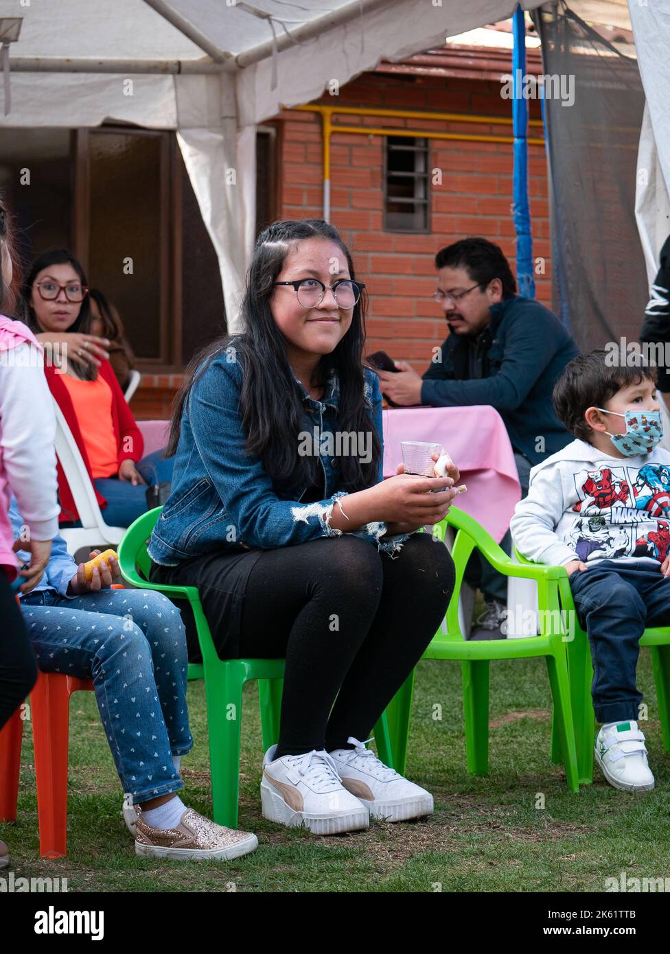 La Paz, Bolivien - 10 2022. September: Mädchen im Teenageralter mit Brille sitzt auf der bolivianischen Kinderparty Stockfoto